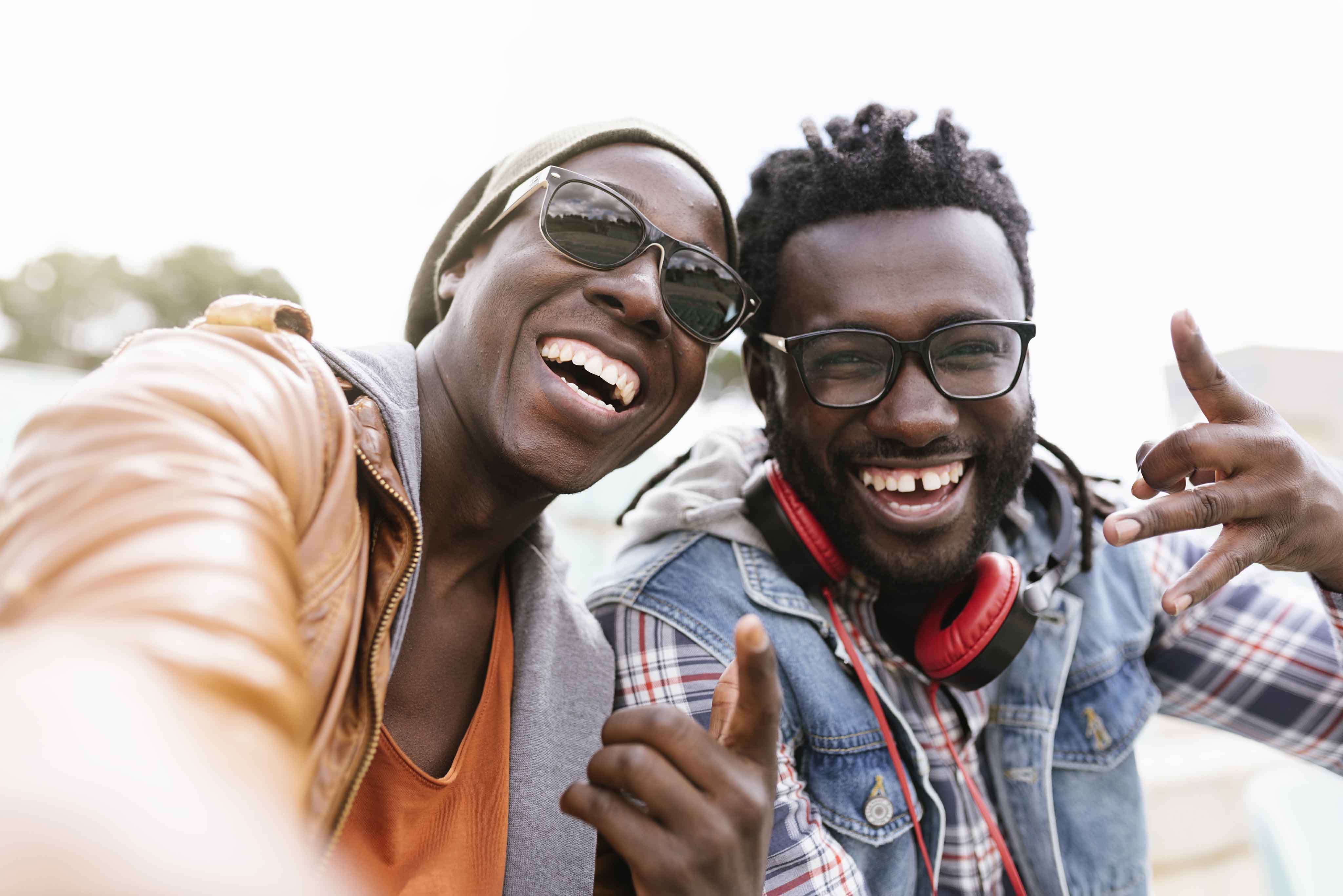 Two dark-skinned people taking a selfie smiling.