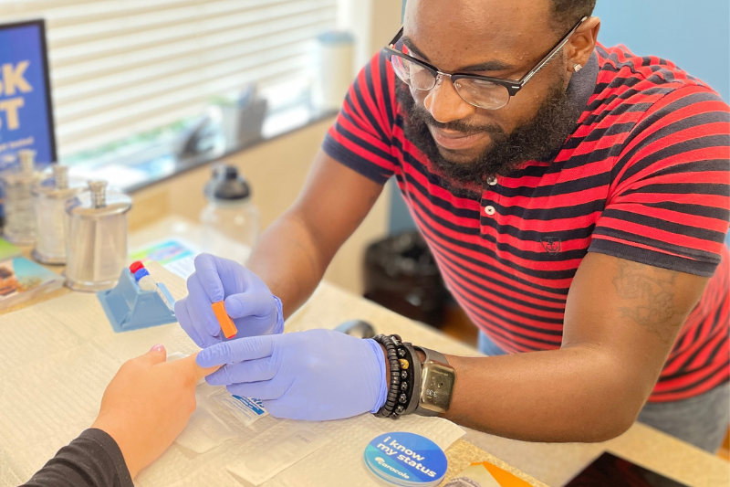 An HIV tester uses a blood test on a client