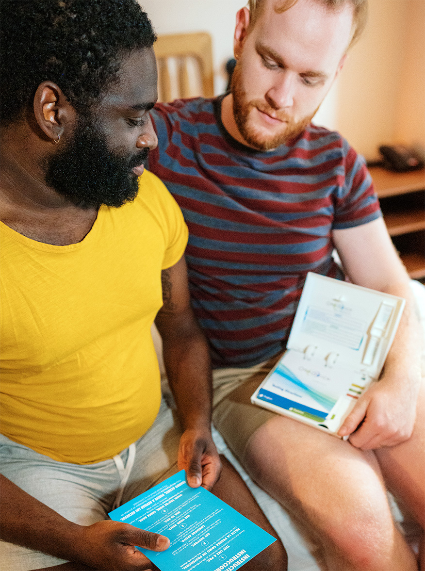 A pair of men looking through the OraQuick HIV at home testing kit.
