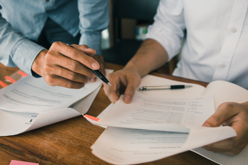 Two people sitting next to each other reviewing paperwork